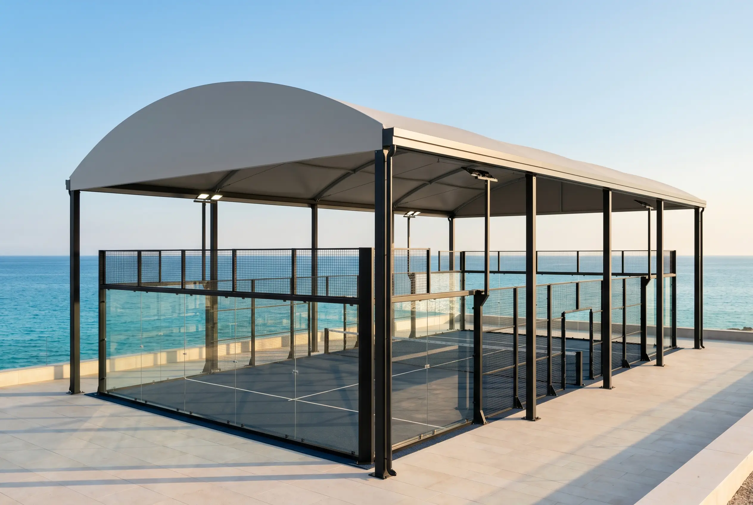 Covered panoramic padel court with a curved roof overlooking the sea