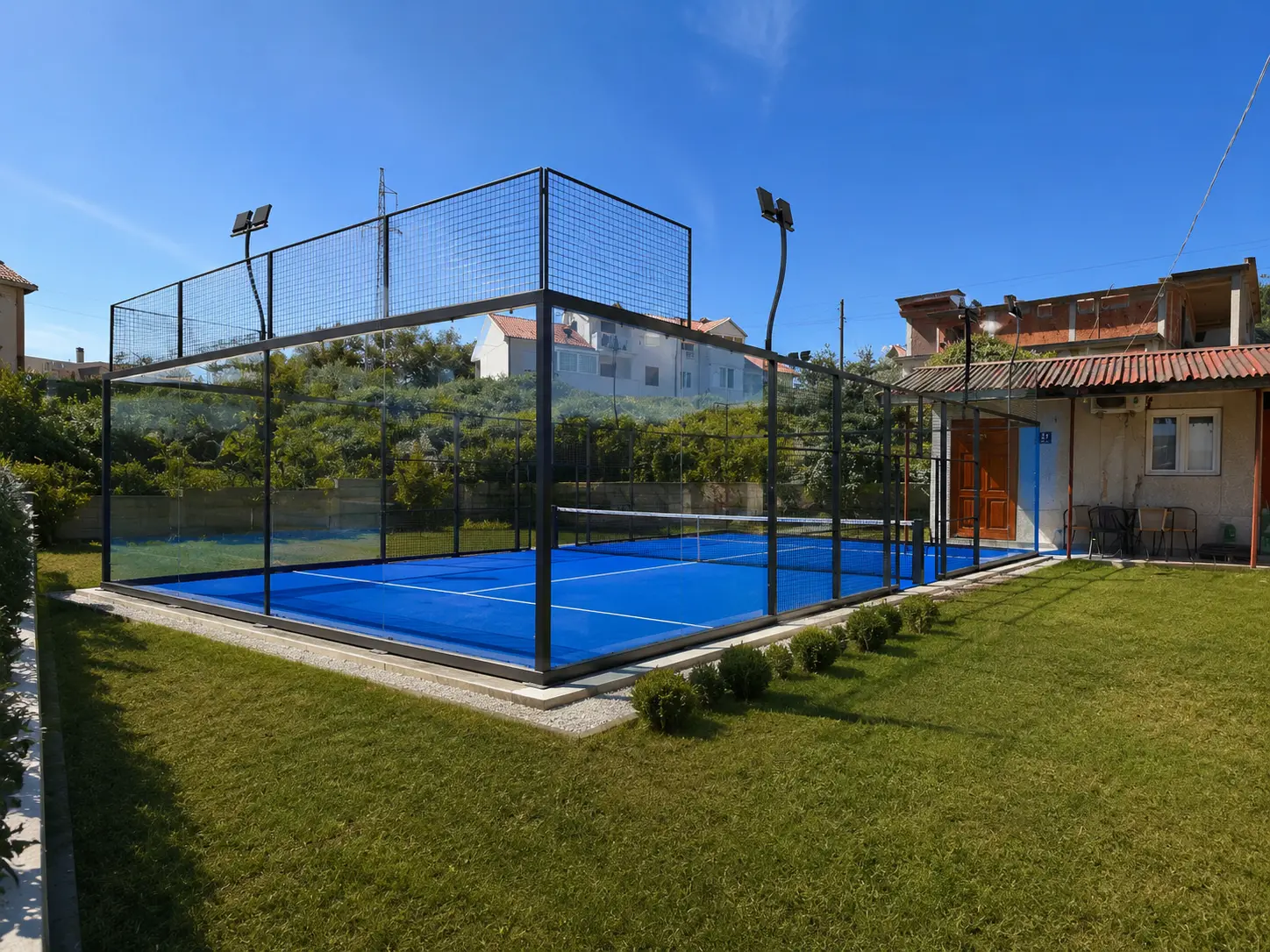 The same garden with a finished panoramic padel court installed